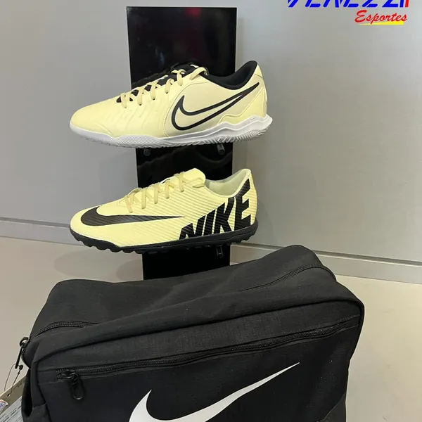 Chuteiras Nike amarelas e bolsa Nike preta